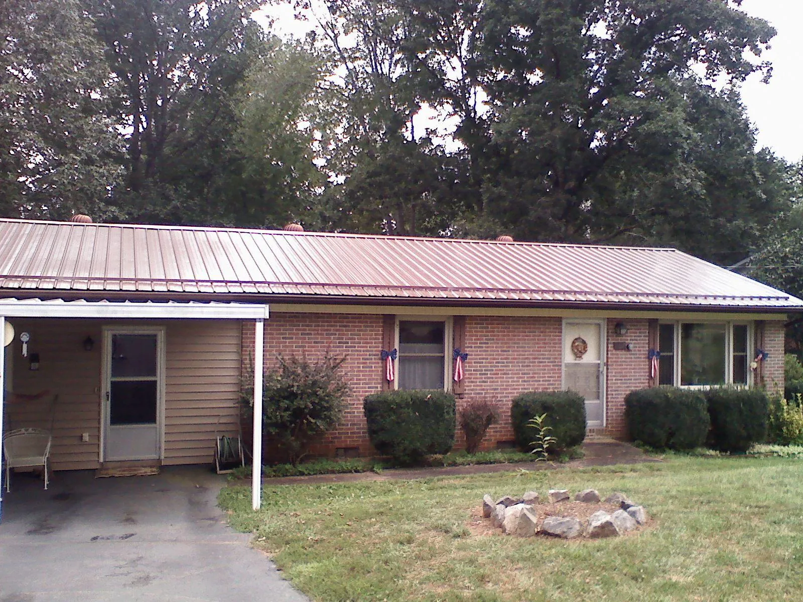 Bronze metal roof and carport on a brick ranch home — Roof Repair work by our crew in Black Creek